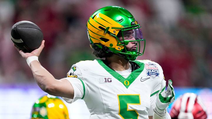 Oregon Ducks quarterback Dante Moore (5) draws back to pass during the Peach Bowl and semifinal game of the College Football Playoff against the Indiana Hoosiers at Mercedes-Benz Stadium in Atlanta. Oregon Ducks quarterback Dante Moore (5) draws back to pass during the Peach Bowl and semifinal game of the College Football Playoff against the Indiana Hoosiers at Mercedes-Benz Stadium in Atlanta.