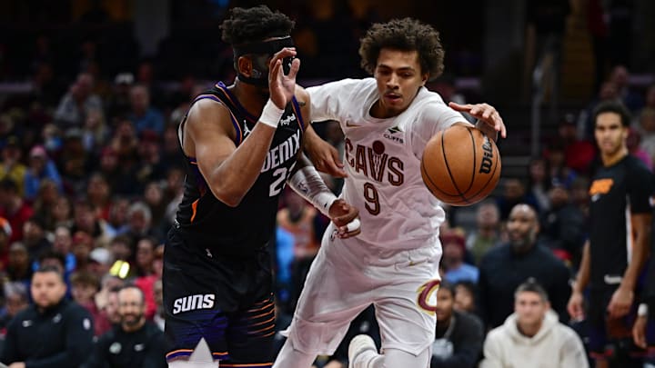 Dec 31, 2025; Cleveland, Ohio, USA; Cleveland Cavaliers guard Craig Porter Jr. (9) attempt to keep a loose ball from going out of bounds while being pressured by Phoenix Suns guard Jordan Goodwin (23) during the second half at Rocket Arena. Mandatory Credit: David Dermer-Imagn Images