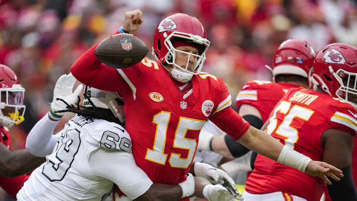 Dec 25, 2023; Kansas City, Missouri, USA; Kansas City Chiefs quarterback Patrick Mahomes (15) fumbles the ball as he is hit by Las Vegas Raiders defensive tackle Adam Butler (69) during the first half at GEHA Field at Arrowhead Stadium. Mandatory Credit: Jay Biggerstaff-Imagn Images