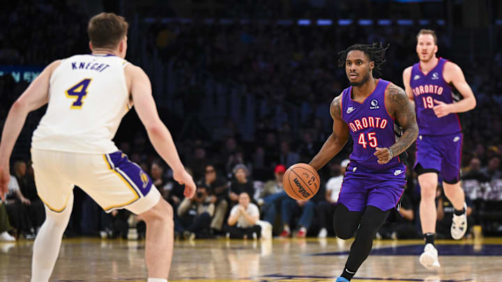 Nov 10, 2024; Los Angeles, California, USA; Toronto Raptors guard Davion Mitchell (45) drives the ball against Los Angeles Lakers guard Dalton Knecht (4) during the second half at Crypto.com Arena. Mandatory Credit: Jonathan Hui-Imagn Images