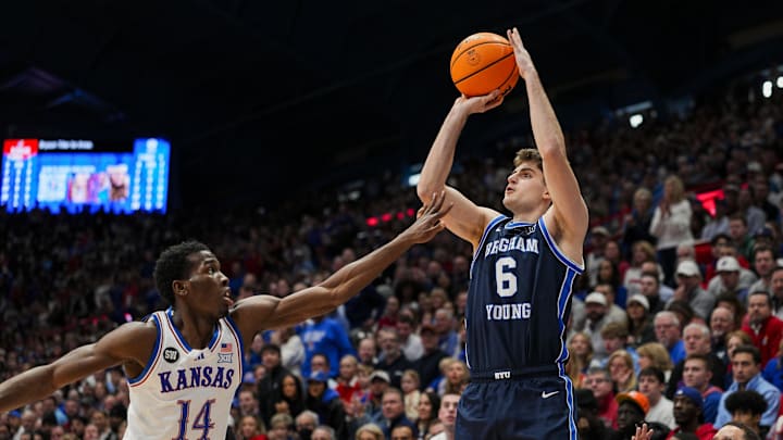 Jan 31, 2026; Lawrence, Kansas, USA; BYU Cougars guard Aleksej Kostic (6) shoots against Kansas Jayhawks guard Melvin Council Jr. (14) during the first half at Allen Fieldhouse. Mandatory Credit: Jay Biggerstaff-Imagn Images