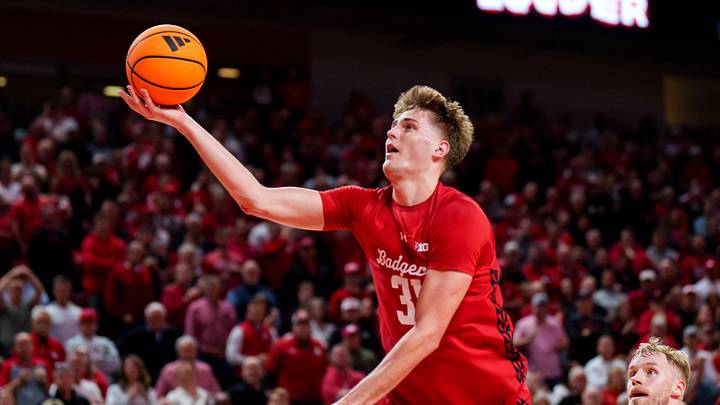 Dec 10, 2025; Lincoln, Nebraska, USA; Wisconsin Badgers forward Nolan Winter (31) fouls against Nebraska Cornhuskers guard Jamarques Lawrence (10) during the second half at Pinnacle Bank Arena. Mandatory Credit: Dylan Widger-Imagn Images