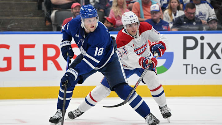 Sep 26, 2024; Toronto, Ontario, CAN;  Toronto Maple Leafs forward Steven Lorentz (18) looks for a pass in front of Montreal Canadiens defenseman David Reinbacher (64) in the third period at Scotiabank Arena. Mandatory Credit: Dan Hamilton-Imagn Images