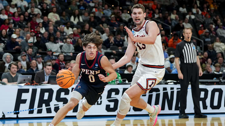 Mar 19, 2026; Greenville, SC, USA; Penn Quakers guard AJ Levine (0) dribbles past Illinois Fighting Illini center Tomislav Ivisic (13) in the second half of a first round game of the men's 2026 NCAA Tournament at Bon Secours Wellness Arena. Mandatory Credit: Bob Donnan-Imagn Images