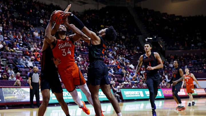Jan 4, 2025; Blacksburg, Virginia, USA; Virginia Tech Hokies forward Mylyjael Poteat (34) shoots the ball against Miami Hurricanes guard Jalen Blackmon (5) during the first half at Cassell Coliseum. Mandatory Credit: Peter Casey-Imagn Images