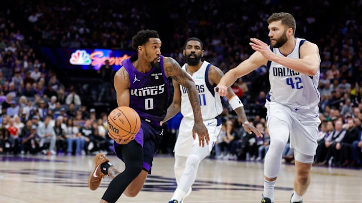 Mar 26, 2024; Sacramento, California, USA; Sacramento Kings guard Malik Monk (0) dribbles the ball past Dallas Mavericks guard Kyrie Irving (11) during the third quarter at Golden 1 Center. Mandatory Credit: Sergio Estrada-Imagn Images