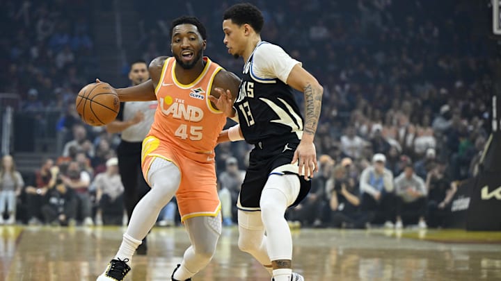 Nov 17, 2025; Cleveland, Ohio, USA; Cleveland Cavaliers guard Donovan Mitchell (45) dribbles beside Milwaukee Bucks guard Ryan Rollins (13) in the first quarter at Rocket Arena. Mandatory Credit: David Richard-Imagn Images