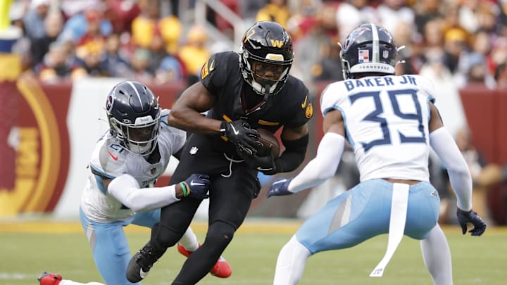 Washington Commanders wide receiver Terry McLaurin carries the ball as Tennessee Titans cornerback Roger McCreary.