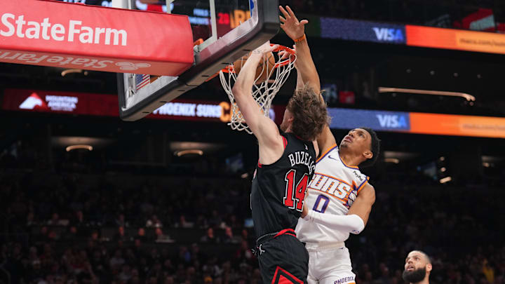 Mar 19, 2025; Phoenix, Arizona, USA; Chicago Bulls forward Matas Buzelis (14) dunks over Phoenix Suns forward Ryan Dunn (0) during the first half at PHX Aena. Mandatory Credit: Joe Camporeale-Imagn Images