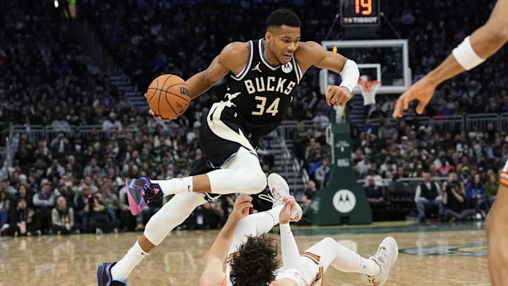 Dec 19, 2023; Milwaukee, Wisconsin, USA;  Milwaukee Bucks forward Giannis Antetokounmpo (34) drives for the basket over San Antonio Spurs forward Cedi Osman (16) during the second quarter at Fiserv Forum. Mandatory Credit: Jeff Hanisch-Imagn Images