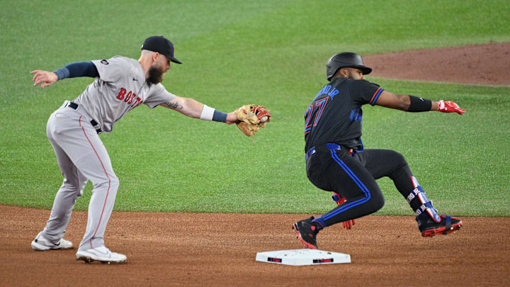 Sep 25, 2024; Toronto, Ontario, CAN; Toronto Blue Jays first baseman Vladimir Guerrero Jr. (27) eludes a tag from Boston Red Sox shortstop Trevor Story (10) after hitting a double in the fourth inning at Rogers Centre. Mandatory Credit: Dan Hamilton-Imagn Images Sep 25, 2024; Toronto, Ontario, CAN; Toronto Blue Jays first baseman Vladimir Guerrero Jr. (27) eludes a tag from Boston Red Sox shortstop Trevor Story (10) after hitting a double in the fourth inning at Rogers Centre. Mandatory Credit: Dan Hamilton-Imagn Images