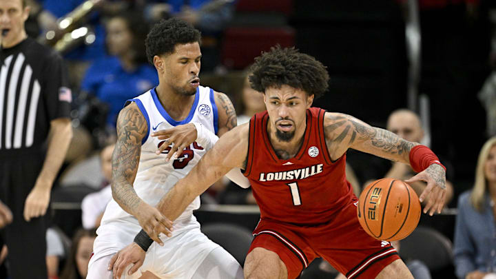 Feb 17, 2026; Dallas, Texas, USA; Louisville Cardinals guard J'vonne Hadley (1) looks to move the ball past SMU Mustangs forward Corey Washington (3) during the second half at Moody Coliseum. Mandatory Credit: Jerome Miron-Imagn Images