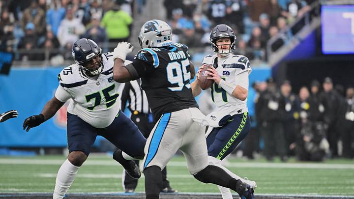 Dec 28, 2025; Charlotte, North Carolina, USA; Seattle Seahawks quarterback Sam Darnold (14) looks to throw a pass as guard Anthony Bradford (75) blocks against Carolina Panthers defensive end Derrick Brown (95) during the first quarter at Bank of America Stadium. Mandatory Credit: Bob Donnan-Imagn Images Dec 28, 2025; Charlotte, North Carolina, USA; Seattle Seahawks quarterback Sam Darnold (14) looks to throw a pass as guard Anthony Bradford (75) blocks against Carolina Panthers defensive end Derrick Brown (95) during the first quarter at Bank of America Stadium. Mandatory Credit: Bob Donnan-Imagn Images