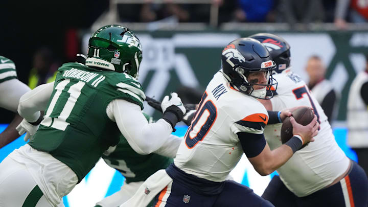 Oct 12, 2025; Tottenham, United Kingdom; Denver Broncos quarterback Bo Nix (10) is pressured by New York Jets linebacker Jermaine Johnson II (11) during an NFL International Series game at Tottenham Hotspur Stadium. Mandatory Credit: Kirby Lee-Imagn Images