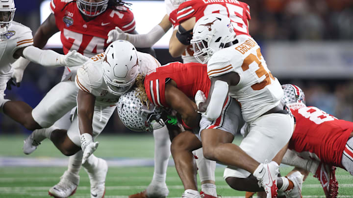 Jan 10, 2025; Arlington, Texas, USA; Texas Longhorns linebacker David Gbenda (33) and linebacker Colin Simmons (11) tackle Ohio State Buckeyes running back Quinshon Judkins (1) during the third quarter of the College Football Playoff semifinal in the Cotton Bowl at AT&T Stadium. Mandatory Credit: Tim Heitman-Imagn Images