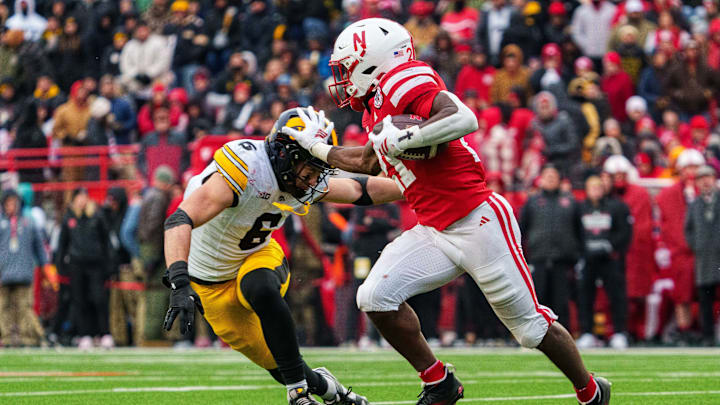 Nov 28, 2025; Lincoln, Nebraska, USA; Nebraska Cornhuskers running back Emmett Johnson (21) runs against Iowa Hawkeyes defensive back Zach Lutmer (6) during the third quarter at Memorial Stadium. Mandatory Credit: Dylan Widger-Imagn Images Nov 28, 2025; Lincoln, Nebraska, USA; Nebraska Cornhuskers running back Emmett Johnson (21) runs against Iowa Hawkeyes defensive back Zach Lutmer (6) during the third quarter at Memorial Stadium. Mandatory Credit: Dylan Widger-Imagn Images