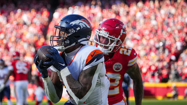 Nov 10, 2024; Kansas City, Missouri, USA; Denver Broncos wide receiver Courtland Sutton (14) catches a pass for a touchdown as Kansas City Chiefs linebacker Drue Tranquill (23) chases during the first half at GEHA Field at Arrowhead Stadium. Mandatory Credit: Denny Medley-Imagn Images