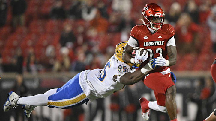 Nov 23, 2024; Louisville, Kentucky, USA; Louisville Cardinals running back Keyjuan Brown (22) runs against Pittsburgh Panthers defensive lineman Francis Brewu (95) during the second half at L&N Federal Credit Union Stadium. Louisville defeated Pittsburgh 37-9. Mandatory Credit: Jamie Rhodes-Imagn Images Nov 23, 2024; Louisville, Kentucky, USA; Louisville Cardinals running back Keyjuan Brown (22) runs against Pittsburgh Panthers defensive lineman Francis Brewu (95) during the second half at L&N Federal Credit Union Stadium. Louisville defeated Pittsburgh 37-9. Mandatory Credit: Jamie Rhodes-Imagn Images