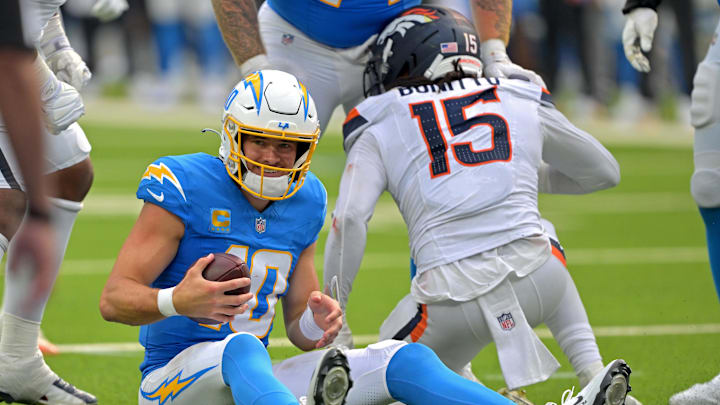 Sep 21, 2025; Inglewood, California, USA;  Los Angeles Chargers quarterback Justin Herbert (10) is sacked by Denver Broncos linebacker Nik Bonitto (15) in the second half at SoFi Stadium. Mandatory Credit: Jayne Kamin-Oncea-Imagn Images