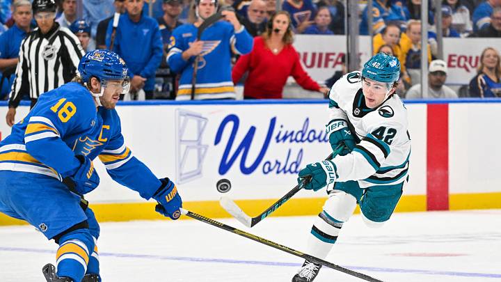 Oct 8, 2026; St. Louis, Missouri, USA; San Jose Sharks defenseman Luca Cagnoni (42) shoots as St. Louis Blues center Robert Thomas (18) defends during the first period at Enterprise Center. Mandatory Credit: Jeff Curry-Imagn Images