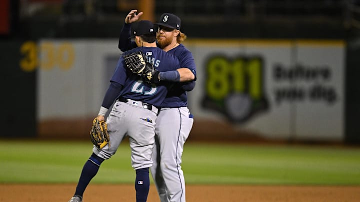 Seattle Mariners third baseman Luis Urías (23) and first baseman Justin Turner (2) hug after their win over the Oakland Athletics at Oakland-Alameda County Coliseum in 2024.