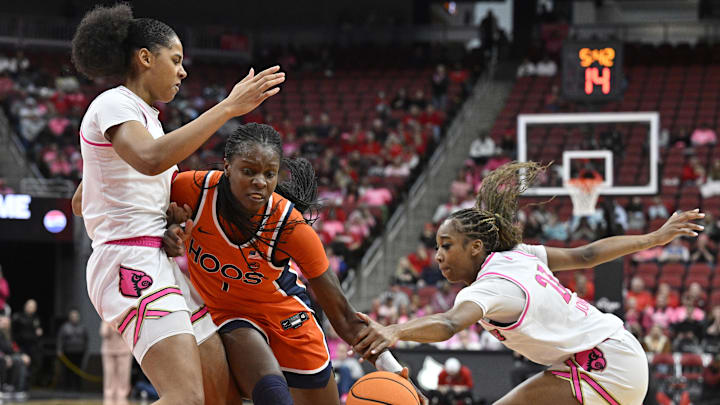 Feb 22, 2026; Louisville, Kentucky, USA;  Virginia Cavaliers forward Tabitha Amanze (7) drives to the basket against Louisville Cardinals forward Anaya Hardy (9) and guard Skylar Jones (23) during the second half at KFC Yum! Center. Mandatory Credit: Jamie Rhodes-Imagn Images