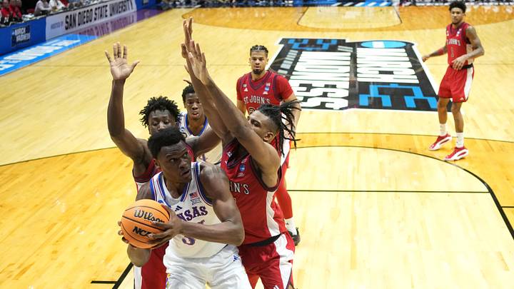 Mar 22, 2026; San Diego, CA, USA; Kansas Jayhawks center Paul Mbiya (34) controls the ball against St. John's Red Storm guard Joson Sanon (3) and St. John's Red Storm forward Zuby Ejiofor (24) in the second half during a second round game of the men's 2026 NCAA Tournament at Viejas Arena. Mandatory Credit: Kirby Lee-Imagn Images