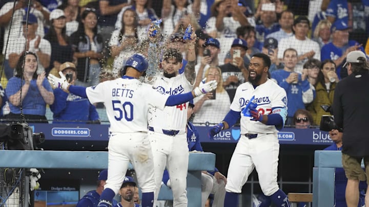 Jul 3, 2025; Los Angeles, California, USA;  Los Angeles Dodgers shortstop Mookie Betts (50) is showered with sunflower seeds by center fielder Andy Pages (44) and right fielder Teoscar Hernandez (37) after homering to left center field in the seventh inning at Dodger Stadium. Mandatory Credit: Kirby Lee-Imagn Images