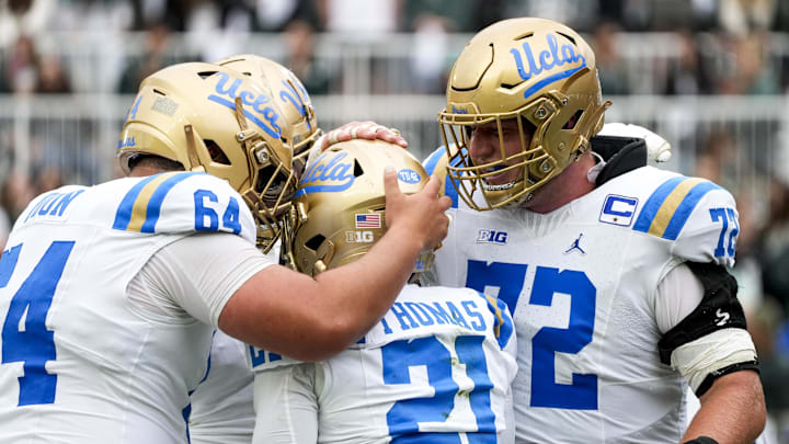 Oct 11, 2025; East Lansing, Michigan, USA; UCLA Bruins offensive linemen celebrate a touchdown with running back Jaivian Thomas (21) in the third quarter at Spartan Stadium. Mandatory Credit: Brendan Mullin-Imagn Images