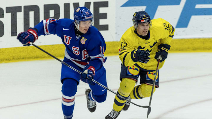 Aug 2, 2024; Plymouth, MI, USA; USA’s forward Colin Ralph (11) battles for position with Sweden's forward Melvin Fernstrom (12) during the second period of the 2024 World Junior Summer Showcase at USA Hockey Arena. Mandatory Credit: David Reginek-Imagn Images