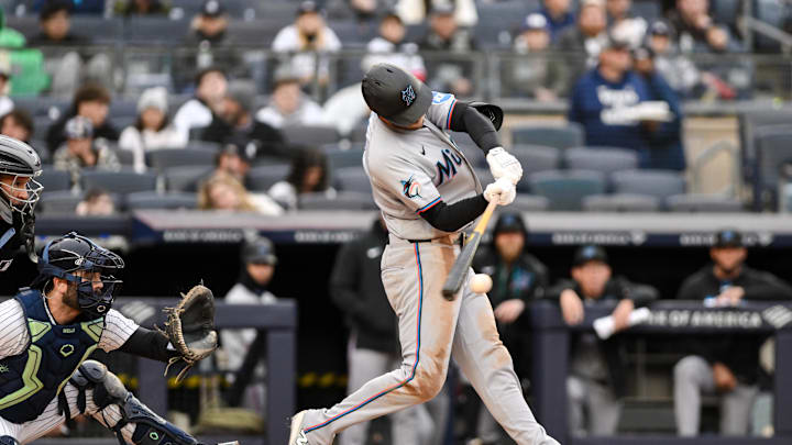 Apr 5, 2026; Bronx, New York, USA; Miami Marlins left fielder Austin Slater (15) hits a single against the New York Yankees during the third inning at Yankee Stadium. Mandatory Credit: John Jones-Imagn Images