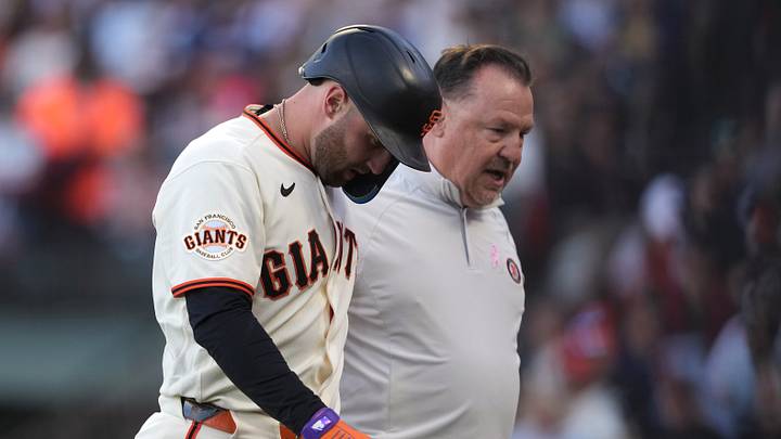 San Francisco, California, USA; San Francisco Giants third baseman Casey Schmitt (left) walks off the field with head of medical and performance Dave Groeschner (right) after suffering an injury during the second inning against the Milwaukee Brewers at Oracle Park. Mandatory Credit: Darren Yamashita-Imagn Images