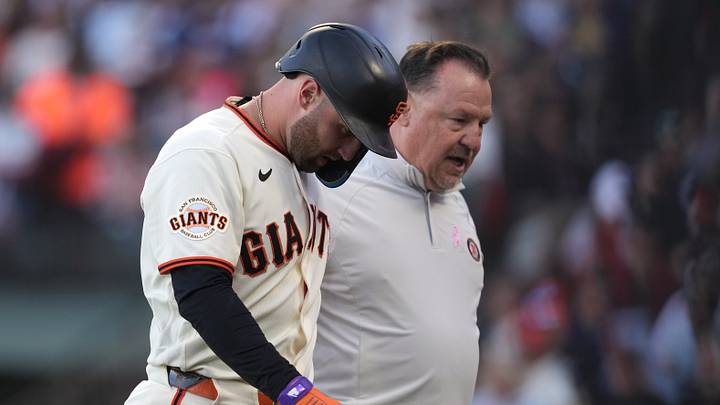 San Francisco, California, USA; San Francisco Giants third baseman Casey Schmitt (left) walks off the field with head of medical and performance Dave Groeschner (right) after suffering an injury during the second inning against the Milwaukee Brewers at Oracle Park. Mandatory Credit: Darren Yamashita-Imagn Images