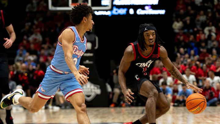 Cincinnati Bearcats guard Day Day Thomas (1) handles the ball as Dayton Flyers forward Nate Santos (2) guards him in the first half of the NCAA men's basketball game between the Dayton Flyers and Cincinnati Bearcats at Heritage Bank Center in Cincinnati on Saturday, Dec. 16, 2023. Cincinnati Bearcats guard Day Day Thomas (1) handles the ball as Dayton Flyers forward Nate Santos (2) guards him in the first half of the NCAA men's basketball game between the Dayton Flyers and Cincinnati Bearcats at Heritage Bank Center in Cincinnati on Saturday, Dec. 16, 2023.