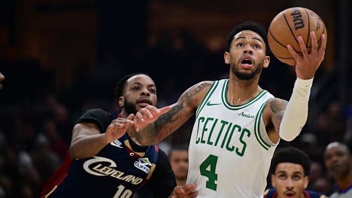 Nov 30, 2025; Cleveland, Ohio, USA; Boston Celtics guard Anfernee Simons (4) goes to the basket Cleveland Cavaliers guard Darius Garland (10) during the first half at Rocket Arena. Mandatory Credit: David Dermer-Imagn Images