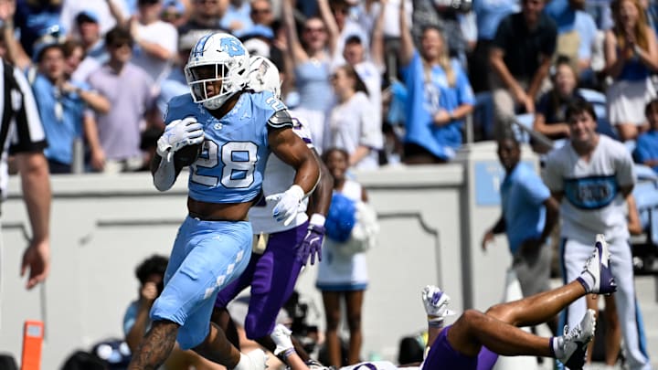 Sep 21, 2024; Chapel Hill, North Carolina, USA; North Carolina Tar Heels running back Omarion Hampton (28) scores a touchdown as James Madison Dukes safety Jacob Thomas (7) defends in the first quarter at Kenan Memorial Stadium. Mandatory Credit: Bob Donnan-Imagn Images