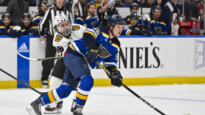 Apr 10, 2024; St. Louis, Missouri, USA;  St. Louis Blues center Zach Dean (52) skates against Chicago Blackhawks center Connor Bedard (98) during the first period at Enterprise Center. Mandatory Credit: Jeff Curry-USA TODAY Sports