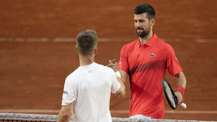 Novak Djokovic of Serbia at the net with Corentin Moutet of France after their match on day five at Roland Garros Stadium.
