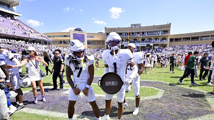 Sep 20, 2025; Fort Worth, Texas, USA; TCU Horned Frogs wide receiver Jordan Dwyer (7) and safety Austin Jordan (1) and celebrate with the Iron Skillet trophy after the Frogs defeat the SMU Mustangs at Amon G. Carter Stadium. Mandatory Credit: Jerome Miron-Imagn Images
