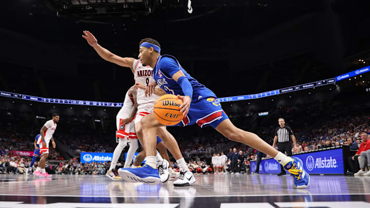 Mar 13, 2025; Kansas City, MO, USA; Kansas Jayhawks guard Dajuan Harris Jr. (3) drives to the basket around Arizona Wildcats forward Carter Bryant (9) during the second half at T-Mobile Center. Mandatory Credit: William Purnell-Imagn Images