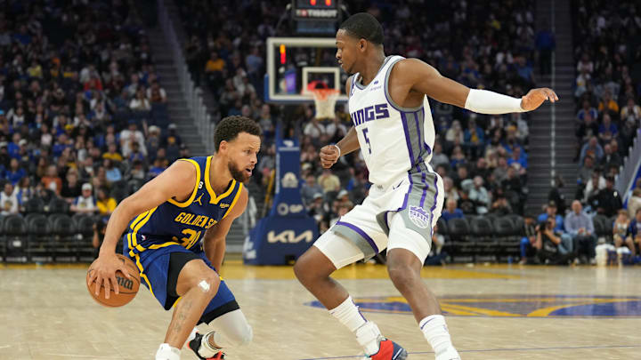 Golden State Warriors guard Stephen Curry (30) dribbles against Sacramento Kings guard De'Aaron Fox (5) during the third quarter at Chase Center. Mandatory Credit: Darren Yamashita-Imagn Images