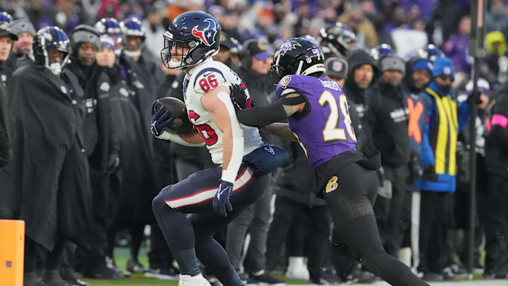 Jan 20, 2024; Baltimore, MD, USA; Houston Texans tight end Dalton Schultz (86) runs the ball against Baltimore Ravens cornerback Ronald Darby (28) during the first quarter of a 2024 AFC divisional round game at M&T Bank Stadium. Mandatory Credit: Mitch Stringer-Imagn Images