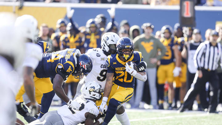 Nov 8, 2025; Morgantown, West Virginia, USA; West Virginia Mountaineers running back Diore Hubbard (20) runs the ball as he’s tackled by Colorado Buffaloes linebacker Jeremiah Brown (42) and Colorado Buffaloes defensive lineman Jehiem Oatis (96) during the first quarter at Milan Puskar Stadium. Mandatory Credit: Ben Queen-Imagn Images Nov 8, 2025; Morgantown, West Virginia, USA; West Virginia Mountaineers running back Diore Hubbard (20) runs the ball as he’s tackled by Colorado Buffaloes linebacker Jeremiah Brown (42) and Colorado Buffaloes defensive lineman Jehiem Oatis (96) during the first quarter at Milan Puskar Stadium. Mandatory Credit: Ben Queen-Imagn Images