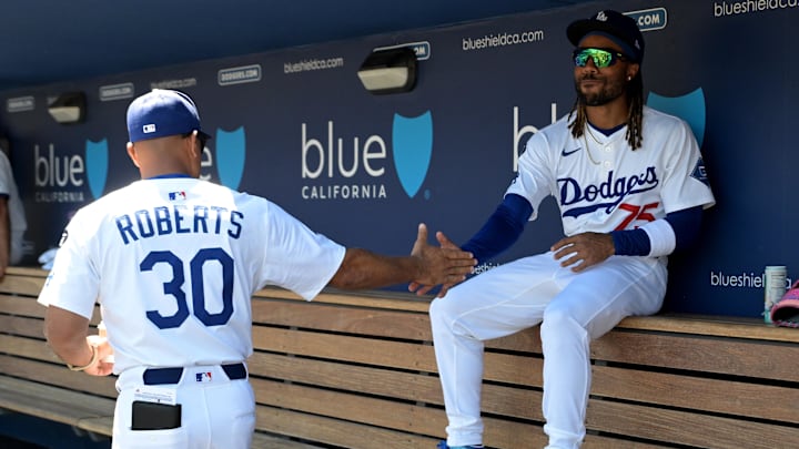 Aug 31, 2025; Los Angeles, California, USA;  Los Angeles Dodgers manager Dave Roberts (30) greets center fielder Justin Dean (75) in the dugout prior to the game against the Arizona Diamondbacks at Dodger Stadium. Mandatory Credit: Jayne Kamin-Oncea-Imagn Images
