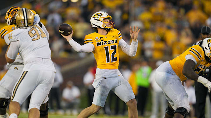Sep 21, 2024; Columbia, Missouri, USA; Missouri Tigers quarterback Brady Cook (12) throws a touchdown pass against the Vanderbilt Commodores during overtime at Faurot Field at Memorial Stadium. Mandatory Credit: Jay Biggerstaff-Imagn Images