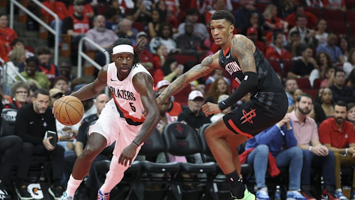 Nov 14, 2025; Houston, Texas, USA;  Portland Trail Blazers guard Jrue Holiday (5) dribbles the ball as Houston Rockets forward Jabari Smith Jr. (10) defneds during the third quarter at Toyota Center. Mandatory Credit: Troy Taormina-Imagn Images