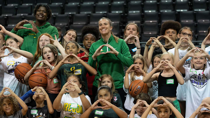 Former Oregon Duck Sabrina Ionescu, center, poses for a photo with some recent Oregon basketball players and area children at Matthew Knight Arena after a basketball clinic Sunday.