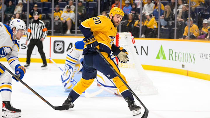 Feb 8, 2025; Nashville, Tennessee, USA; Nashville Predators center Ryan O'Reilly (90) passes the puck behind him against the Buffalo Sabres  during the first period at Bridgestone Arena. Mandatory Credit: Steve Roberts-Imagn Images
