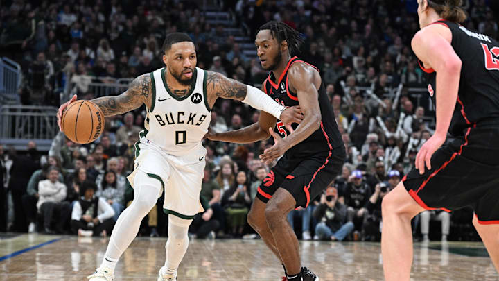 Apr 5, 2024; Milwaukee, Wisconsin, USA; Milwaukee Bucks guard Damian Lillard (0) brings the ball up the court against the Toronto Raptors guard Immanuel Quickley (5)  in the second half at Fiserv Forum. Mandatory Credit: Michael McLoone-Imagn Images