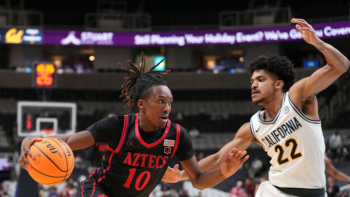 Dec 21, 2024; San Jose, California, USA; San Diego State Aztecs guard BJ Davis (10) dribbles against California Golden Bears guard Christian Tucker (22) during the first half at SAP Center. Mandatory Credit: Darren Yamashita-Imagn Images